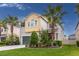 A charming two-story home with lush landscaping and well-manicured lawn featuring palm trees at 1570 Ludington Ave, Wesley Chapel, FL 33543