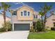 Charming two-story home featuring a two-car garage and well-manicured landscaping with palm trees at 1570 Ludington Ave, Wesley Chapel, FL 33543