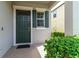 Close up of the front door with dark green shutters, a door bell and small window above the door at 1570 Ludington Ave, Wesley Chapel, FL 33543