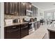Updated kitchen featuring dark wood cabinetry, granite countertops, and stainless steel appliances at 1570 Ludington Ave, Wesley Chapel, FL 33543