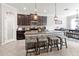 Bright and modern kitchen featuring an island with barstool seating, dark cabinets and stainless steel appliances at 1570 Ludington Ave, Wesley Chapel, FL 33543