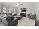 Cozy living room featuring a gray sectional, area rug, ceiling fan and a dark wood entertainment center at 1570 Ludington Ave, Wesley Chapel, FL 33543
