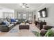 Comfortable living room with a gray sectional, ceiling fan, large television and neutral color scheme at 1570 Ludington Ave, Wesley Chapel, FL 33543