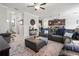 Open-concept living room featuring a dark leather sectional, dark wood cabinets and a view into the kitchen at 1570 Ludington Ave, Wesley Chapel, FL 33543