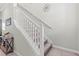 Well-lit staircase featuring white railings and neutral carpeting for a clean and modern design at 1570 Ludington Ave, Wesley Chapel, FL 33543