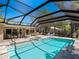 Gorgeous screened pool area featuring a spa, outdoor seating, and an outdoor kitchen space, perfect for entertaining at 1764 Floyd St, Sarasota, FL 34239