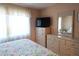 Bedroom featuring a dresser, TV, and large mirror, capturing comfort and functionality in a peaceful setting at 1838 Sunny Dr # D35, Bradenton, FL 34207