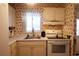 Galley kitchen with white appliances, decorative wallpaper, and window over the sink at 1838 Sunny Dr # D35, Bradenton, FL 34207