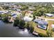 Waterfront home featuring a screened in lanai, private dock, and mature trees on the canal at 18422 Burkholder Cir, Port Charlotte, FL 33948