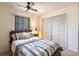 Cozy bedroom with a wooden bed frame, side table, and white closets providing ample storage space at 18422 Burkholder Cir, Port Charlotte, FL 33948