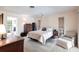 Bright bedroom featuring a comfortable bed, chair, and ample natural light from the nearby windows at 18422 Burkholder Cir, Port Charlotte, FL 33948