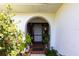 Inviting arched front entrance adorned with greenery and decorative accents at 18422 Burkholder Cir, Port Charlotte, FL 33948