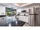 Bright kitchen featuring granite counters, stainless steel appliances, and white cabinetry at 18422 Burkholder Cir, Port Charlotte, FL 33948