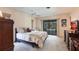 Spacious primary bedroom with carpeted floors, ceiling fan, and sliding glass doors to outside at 18422 Burkholder Cir, Port Charlotte, FL 33948