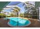 Inviting screened-in pool surrounded by lush landscaping, creating a private oasis at 18422 Burkholder Cir, Port Charlotte, FL 33948