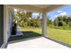 Backyard with a covered patio, lush green lawn, and natural landscaping at 1871 Waltrip St, North Port, FL 34287