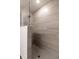 Modern walk-in shower with light tile walls, glass partition, and gray tiled floor at 1871 Waltrip St, North Port, FL 34287