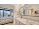 Bright bathroom with a marble countertop vanity, mirror, and a bedroom view with a balcony at 1935 Gulf Of Mexico Dr # G7-402, Longboat Key, FL 34228