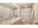 Bright bathroom featuring a marble countertop vanity, mirror, and shower with modern fixtures at 1935 Gulf Of Mexico Dr # G7-402, Longboat Key, FL 34228