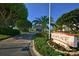 Welcoming community entrance with lush landscaping, signage, and a guardhouse at 1935 Gulf Of Mexico Dr # G7-402, Longboat Key, FL 34228