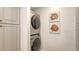 Laundry room featuring stacked washer and dryer, storage and whimsical wall decor at 1935 Gulf Of Mexico Dr # G7-402, Longboat Key, FL 34228