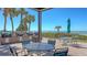 Charming outdoor seating area with a picturesque view of the ocean and surrounding palm trees at 1935 Gulf Of Mexico Dr # G7-402, Longboat Key, FL 34228