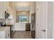 Modern kitchen with stainless steel appliances, white cabinets, stone countertops and a view to the rear at 23819 Collina Way # 202, Port Charlotte, FL 33980