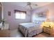 Bright bedroom with double bed, neutral tones, ceiling fan and a bedside lamp and a window at 25275 Rampart Blvd # 1203, Punta Gorda, FL 33983