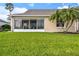 Well manicured backyard featuring a lush lawn, mature palm trees, and a screened-in patio for outdoor enjoyment at 2912 Fiddlers Bnd, Palmetto, FL 34221