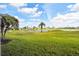 Expansive backyard with lush green grass, swaying palm trees, tranquil ponds, and serene neighborhood views at 2912 Fiddlers Bnd, Palmetto, FL 34221