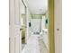 Well-lit bathroom featuring white-tiled floors, ample cabinet space, and a shower with tub at 2912 Fiddlers Bnd, Palmetto, FL 34221