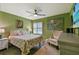 Green bedroom with a floral bedspread, ceiling fan, and a world map on the wall at 2912 Fiddlers Bnd, Palmetto, FL 34221