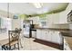 Bright eat-in kitchen boasts white cabinets, stainless steel appliances, tile floors, and a view to the outside at 2912 Fiddlers Bnd, Palmetto, FL 34221