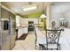 Well-lit kitchen featuring white cabinets, stainless steel appliances, and a view into the dining area at 2912 Fiddlers Bnd, Palmetto, FL 34221