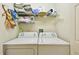 Functional laundry room with washer, dryer, and shelving for storage at 2912 Fiddlers Bnd, Palmetto, FL 34221
