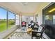Relaxing enclosed patio with comfortable seating and a view of lush landscaping at 2912 Fiddlers Bnd, Palmetto, FL 34221