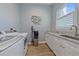 Well-equipped laundry room with modern appliances, a sink, and a decorative fish art piece at 29527 Leah Rd, Punta Gorda, FL 33982