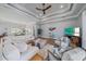 Bright living room with tray ceiling, wood floors, comfortable seating, and an open layout to the dining area at 29527 Leah Rd, Punta Gorda, FL 33982