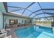 Stunning screened-in pool area with ample seating, fire pit and outdoor kitchen, perfect for entertaining and relaxation at 29527 Leah Rd, Punta Gorda, FL 33982