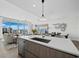 Open-concept kitchen and living area with a view, featuring a large island with counter seating at 301 Quay Commons # 1708, Sarasota, FL 34236