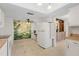 Open kitchen area featuring a decorative mural, white appliances, and ample cabinet space at 3328 Dartmouth Ln # 1012, Sarasota, FL 34239