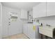 A clean laundry room featuring washer, dryer, and sink at 3328 Dartmouth Ln # 1012, Sarasota, FL 34239