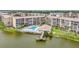 Scenic aerial view of lakeside condos featuring a pool, clubhouse, and private dock for outdoor enjoyment at 3821 Lake Bayshore Dr # H-507, Bradenton, FL 34205