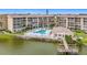 Scenic view of lakeside condos with a large pool, private dock, and well maintained green spaces at 3821 Lake Bayshore Dr # H-507, Bradenton, FL 34205