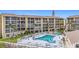 Aerial view of the community pool surrounded by lounge seating and the buildings at 3821 Lake Bayshore Dr # H-507, Bradenton, FL 34205