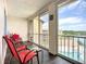 Enclosed lanai with seating offers views of the pool, lake, and surrounding buildings at 3821 Lake Bayshore Dr # H-507, Bradenton, FL 34205