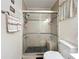 Bathroom featuring a glass-enclosed shower with built-in seating, a toilet, and tile flooring at 3821 Lake Bayshore Dr # H-507, Bradenton, FL 34205