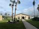 Exterior view of the community clubhouse, showing its entrance, palm trees, and landscaping at 3821 Lake Bayshore Dr # H-507, Bradenton, FL 34205