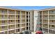 Building exterior with elevator access to upper floors, a private parking area, and well-maintained landscaping at 3821 Lake Bayshore Dr # H-507, Bradenton, FL 34205