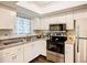 Bright kitchen with white cabinetry and modern stainless steel appliances, designed for convenient meal preparation at 3821 Lake Bayshore Dr # H-507, Bradenton, FL 34205
